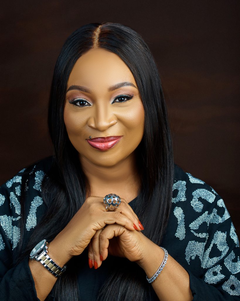 Portrait of Uche Etiaba with her hands gently clasped