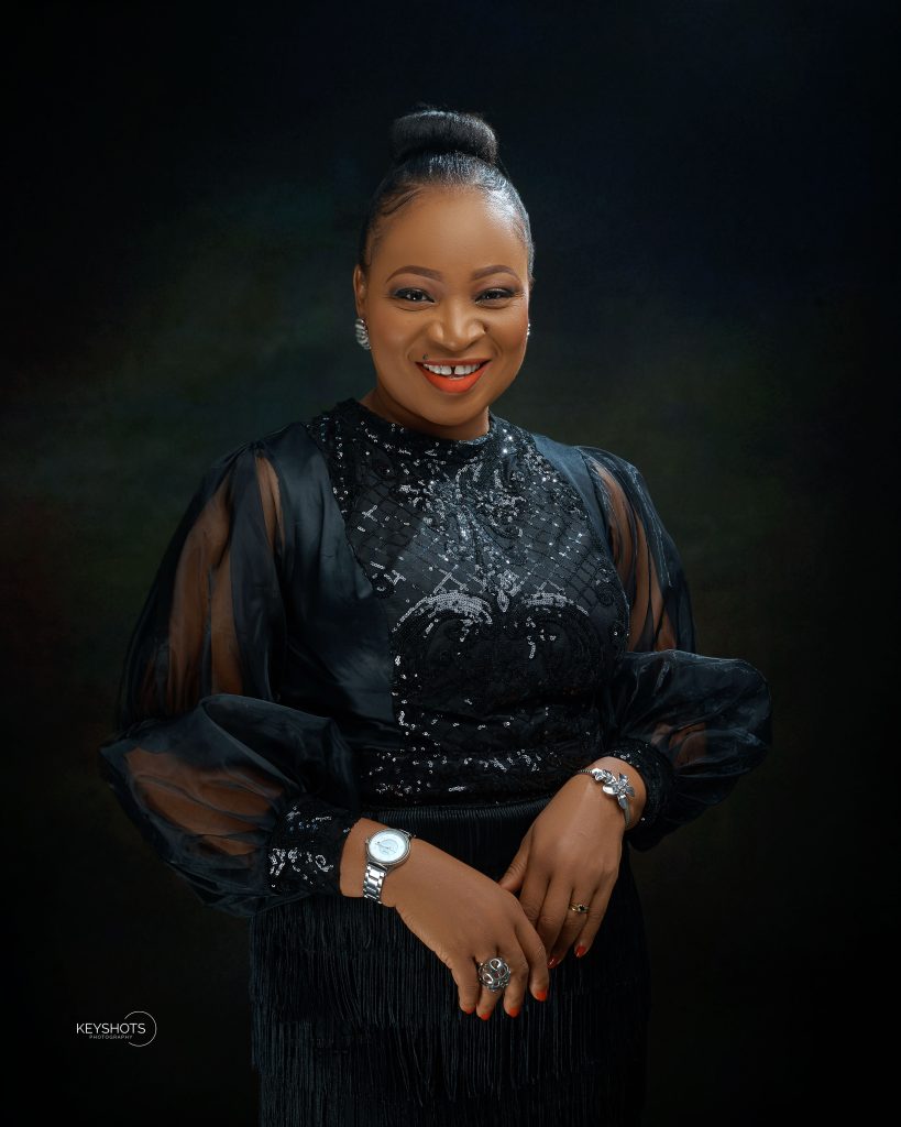 Uche Etiaba smiling in a black dress